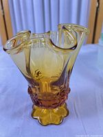 Front three-quarter view of amberina handkerchief vase showing gradient color, hobnail decoration and scalloped foot