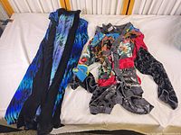 Both garments laid flat: blue/black velvet coat and multicolor patchwork cardigan