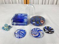 All seven glass paperweights laid out