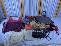 overview of all ten handbags and purses laid out on bed