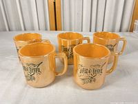 Five orange lustre Fire-King Tom & Jerry mugs front view
