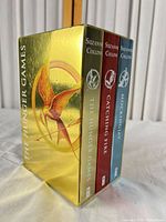 Front view showing book spines inside metallic slipcase