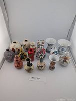 Group shot of all sixteen miniature porcelain vases