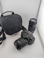 Camera body with 18-55 mm lens attached, 55-250 mm lens, carrying case