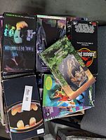 Pile of assorted VHS tapes including Final Destination, Jurassic Park, XXX