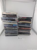 Two stacks of CDs showing quantity and assorted titles
