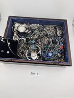 wooden box filled with assorted silver-tone jewelry and watches