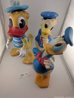 Three Donald Duck vinyl items grouped
