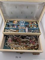 Overall view of jewelry box filled with assorted costume jewelry pieces