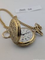 Pocket watch open showing dial and partial case design