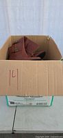 Cardboard box showing top of brown boots