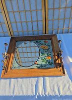 Front view showing full rectangular framed mirror with tilt side supports and floral border