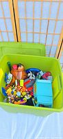 open green tote showing mixed plastic toys