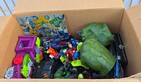 Overview of box showing Hulk fists, Iron Man figure, bat-style vehicle, target board, playset pieces