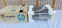 Cassette deck in styrofoam cradle beside original Pioneer CT-F650 box