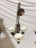 Full view of 3-light chandelier with shades, chain and canopy visible
