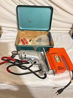 Overview of drill, sabre saw and open teal case with accessories