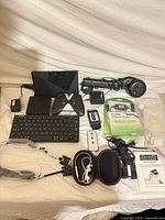 All items laid out including Nvidia Shield, controller, switch, keyboard, earbuds, packaged cable, Handy Hanger, telephone handset, power adapters and cables