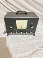 Front view of Heathkit IM-12 meter showing analog dial, knobs, and handle