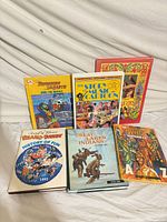 Front view of all six hardcover books standing and lying flat