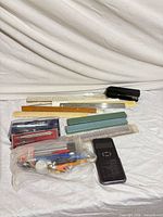 Group shot showing rulers, scales, stapler, calculator, compass sets and bag of assorted pencils/pens