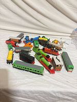 Group view of all toy trains and rolling stock spread on cloth