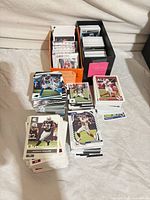 Two long card boxes and several stacks of NFL trading cards