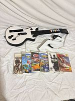 Group shot of guitar controller, Wii Zapper shell with Remote, Nunchuk and six game cases