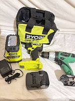Group shot showing Ryobi impact driver, Hitachi drill, Ryobi charger, Hitachi battery, Ryobi tool bag