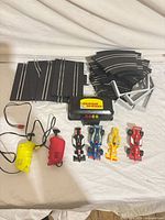 Full set laid out: track pieces, power box, controllers, cars, supports