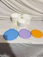 Three nesting bowls and three lids displayed