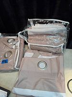 Two panels in clear packaging showing grommets and fabric