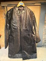 Full view of black leather coat hanging to show overall style and condition