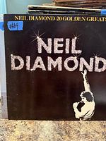 Front cover of Neil Diamond 20 Golden Greats LP with partial view of additional albums behind