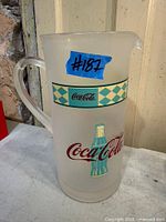 Full view Coca-Cola frosted glass pitcher showing graphics and handle