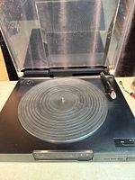 Turntable with dust cover open showing platter and tonearm