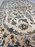 Angled view showing ivory field and floral motifs