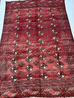 Full view of red Turkman rug showing overall design and size