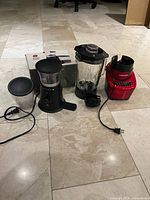 Blender components, coffee grinder and box displayed on tile floor