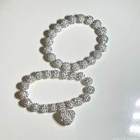 Two pavé crystal bead stretch bracelets displayed on white surface