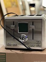 Front view of stainless steel Cuisinart 4-slice digital toaster showing LCD screen, levers and controls