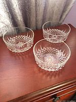 Three Arcorac pressed-glass bowls on wood surface