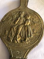 Front view highlighting embossed Dutch scene on brass panel