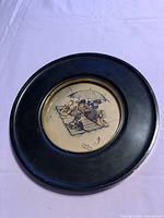 Full view of circular frame front showing print and gold trim