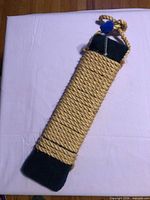 Full view of sisal rope scratch board with carpet ends and hanging loop