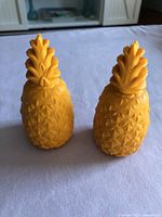 Front view of two yellow pineapple dog treat holders upright
