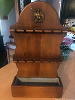 front view showing entire rack, eagle motif, spoon slots and tin-lined box