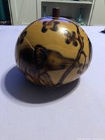 Side view showing elephant pyrography on gourd jar