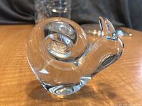 Front side view of clear glass snail figurine showing spiral shell and body