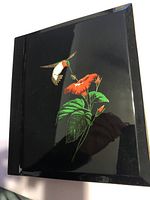 Front cover showing hummingbird and red flower design on black lacquer